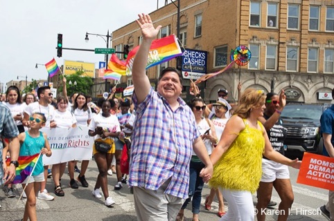 Governor J.B. Pritzker waving and his wife 